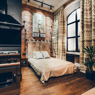 Modelo de dormitorio industrial con paredes rojas, suelo de madera oscura y suelo marrón