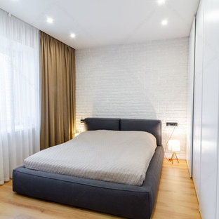 Diseño de dormitorio principal, industrial, pequeño, sin chimenea, con paredes blancas, suelo laminado y suelo beige