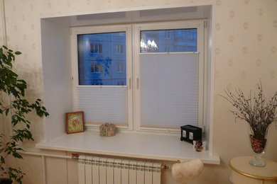 Modelo de dormitorio principal clásico renovado pequeño con paredes beige, suelo de madera en tonos medios y suelo multicolor