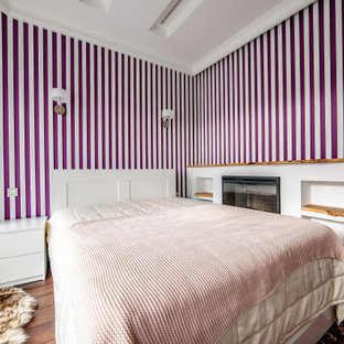 Immagine di una grande camera degli ospiti design con pareti rosa, pavimento in laminato, camino lineare Ribbon, cornice del camino in legno, pavimento marrone, soffitto ribassato e pareti in legno