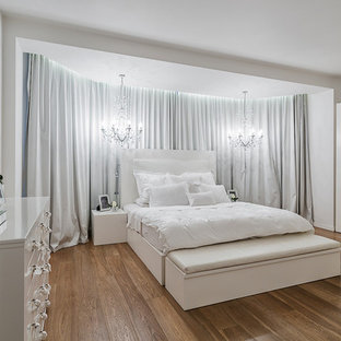 Photo of a contemporary master bedroom in Moscow with white walls and medium hardwood flooring.