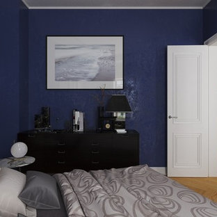Diseño de dormitorio principal, urbano, de tamaño medio, con paredes azules y suelo de madera clara