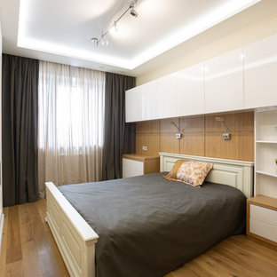 Immagine di una camera degli ospiti design di medie dimensioni con pareti beige, pavimento in legno massello medio e pavimento giallo