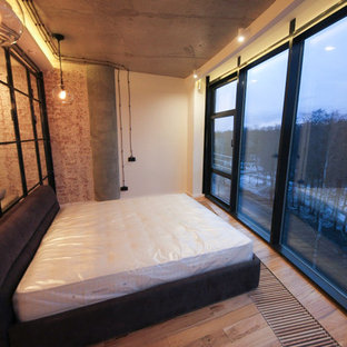Imagen de dormitorio principal, urbano, pequeño, sin chimenea, con paredes blancas, suelo laminado y suelo beige