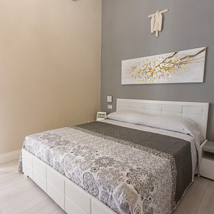 Diseño de dormitorio principal, actual, pequeño, con paredes grises, suelo laminado y suelo gris