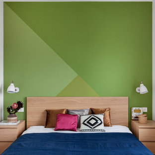 Modelo de dormitorio principal, escandinavo, de tamaño medio, con paredes verdes y suelo de madera en tonos medios
