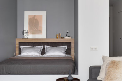 Идея дизайна: спальня в современном стиле с серыми стенами, паркетным полом среднего тона, коричневым полом и кроватью в нише