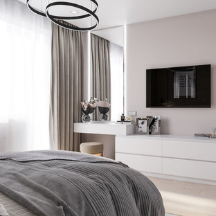 Imagen de dormitorio principal, actual, pequeño, con paredes beige, suelo laminado y suelo marrón