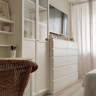 Foto de dormitorio principal, actual, pequeño, sin chimenea, con paredes beige, suelo laminado y suelo marrón