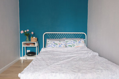 Ejemplo de dormitorio principal escandinavo pequeño con paredes azules, suelo laminado y suelo beige