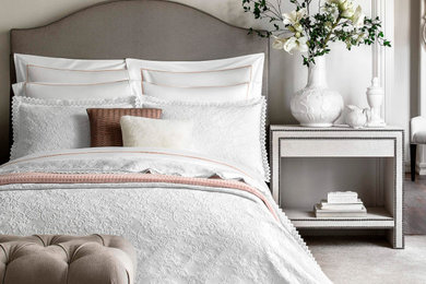 На фото: хозяйская спальня в стиле неоклассика (современная классика) с белыми стенами, ковровым покрытием и бежевым полом с