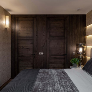 Kleines Klassisches Hauptschlafzimmer mit brauner Wandfarbe, dunklem Holzboden, braunem Boden und Tapetenwänden in Moskau
