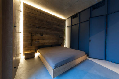 Imagen de dormitorio principal urbano de tamaño medio sin chimenea con paredes grises, suelo de cemento y suelo gris