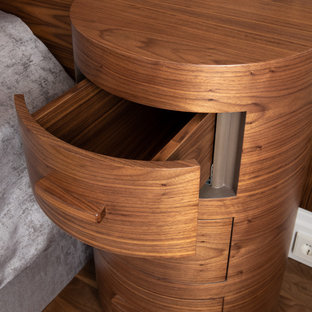 Modelo de dormitorio principal, actual, grande, sin chimenea, con paredes grises, suelo laminado y suelo marrón