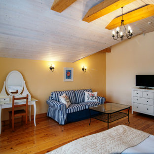 Ejemplo de habitación de invitados urbana, sin chimenea, con paredes amarillas y suelo de madera pintada
