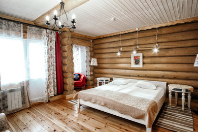 На фото: большая гостевая спальня (комната для гостей) в стиле ретро с коричневыми стенами и деревянным полом без камина