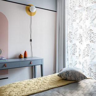 Imagen de dormitorio principal, nórdico, de tamaño medio, con paredes multicolor, suelo laminado y suelo marrón