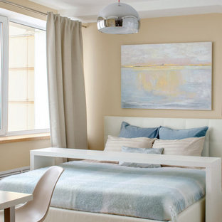 Modelo de dormitorio principal, contemporáneo, pequeño, con paredes beige, suelo laminado y suelo beige