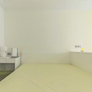 Modelo de dormitorio principal, actual, pequeño, sin chimenea, con paredes amarillas, suelo de corcho y suelo blanco