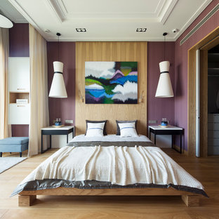 Exemple d'une chambre parentale tendance avec un mur violet et un sol en bois clair.