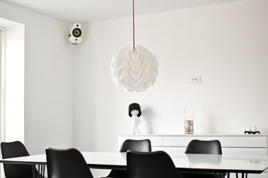 Cette image montre une salle à manger minimaliste fermée et de taille moyenne avec un mur blanc, un sol en carrelage de céramique et aucune cheminée.