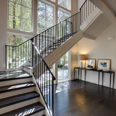 Example of a large transitional wooden u-shaped metal railing staircase design in Atlanta with painted risers