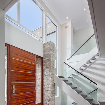 2-story foyer with glass and wood staircase and African mahogany front door