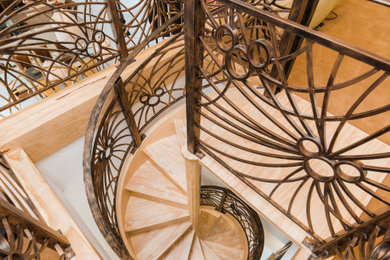 Diseño de escalera de caracol con escalones de madera, contrahuellas de madera y barandilla de metal