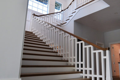 Diseño de escalera en U con escalones de madera, contrahuellas de madera y barandilla de madera