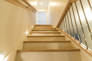 Diseño de escalera contemporánea con escalones de madera, contrahuellas de madera y barandilla de madera