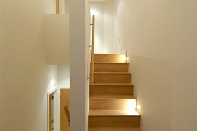 Medium sized modern wood u-shaped staircase in London with wood risers.