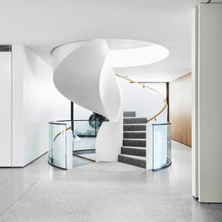 Design ideas for a modern carpeted spiral staircase in Melbourne with carpet risers and glass railing.