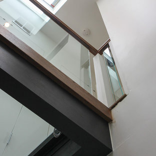 Immagine di un'ampia scala sospesa design con pedata in vetro, nessuna alzata e parapetto in vetro
