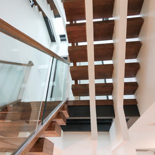 Ispirazione per un'ampia scala sospesa design con pedata in vetro, nessuna alzata e parapetto in vetro
