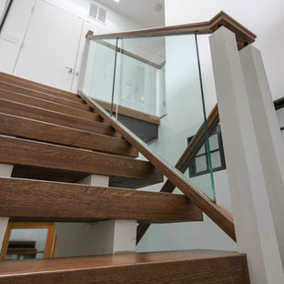 Esempio di un'ampia scala sospesa minimal con pedata in vetro, nessuna alzata e parapetto in vetro