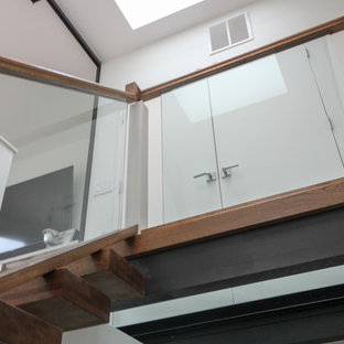 Immagine di un'ampia scala sospesa minimal con pedata in vetro, nessuna alzata e parapetto in vetro