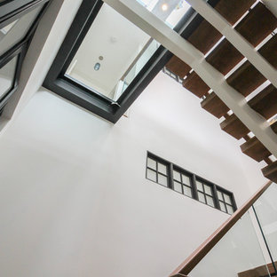 Esempio di un'ampia scala sospesa contemporanea con pedata in vetro, nessuna alzata e parapetto in vetro