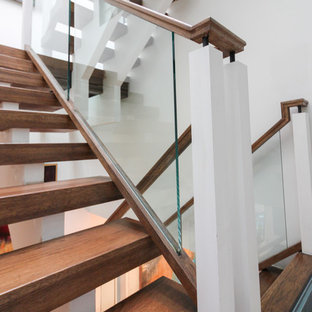 Foto di un'ampia scala sospesa design con pedata in vetro, nessuna alzata e parapetto in vetro