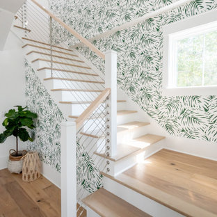 Foto på en stor tropisk u-trappa i trä, med sättsteg i trä och kabelräcke