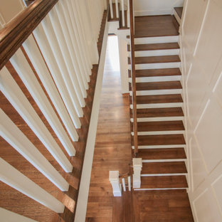 Große Klassische Holztreppe in U-Form mit Holz-Setzstufen, Holzgeländer und vertäfelten Wänden in Washington, D.C.