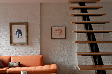 Diseño de escalera suspendida minimalista sin contrahuella con escalones de madera y barandilla de metal