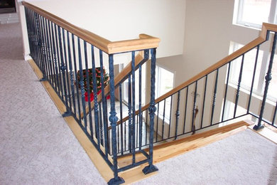 Ejemplo de escalera recta clásica de tamaño medio con escalones de madera y barandilla de metal