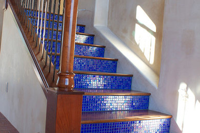 Imagen de escalera recta mediterránea con escalones de madera y contrahuellas con baldosas y/o azulejos