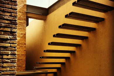 Réalisation d'un très grand escalier design avec des marches en métal et des contremarches en métal.