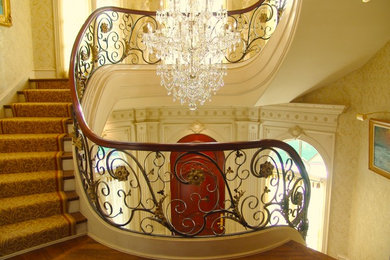 Imagen de escalera curva clásica con escalones de madera y contrahuellas de madera pintada