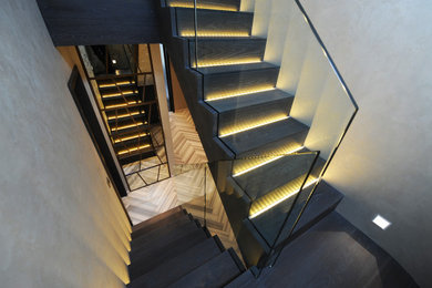 Inspiration for a medium sized contemporary spiral glass railing staircase in London.