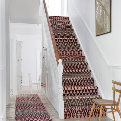 Elegant carpeted u-shaped staircase photo in Hampshire with carpeted risers