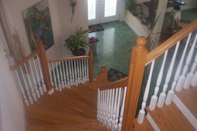 Modelo de escalera curva de estilo americano de tamaño medio con escalones de madera y barandilla de madera