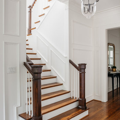 Elegant wooden u-shaped staircase photo in Houston with painted risers