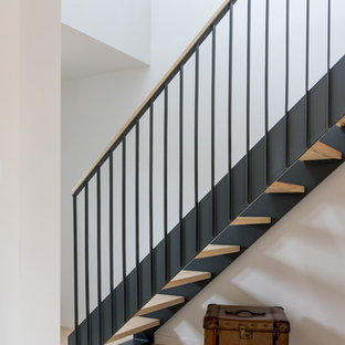 Aménagement d'un escalier sans contremarche droit scandinave de taille moyenne avec des marches en bois et un garde-corps en métal.